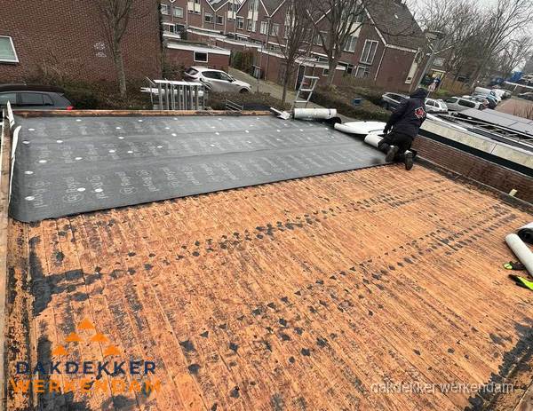 Dakdekker legt onderlaag op plat dak met houten constructie in Werkendam