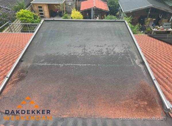 Verouderd plat dak met slijtage tussen schuine daken in Werkendam Verouderd plat dak met slijtage tussen schuine daken in Werkendam