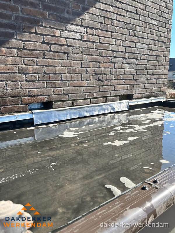 Stilstaand water op plat dak door slechte afwatering in Werkendam Stilstaand water op plat dak door slechte afwatering in Werkendam