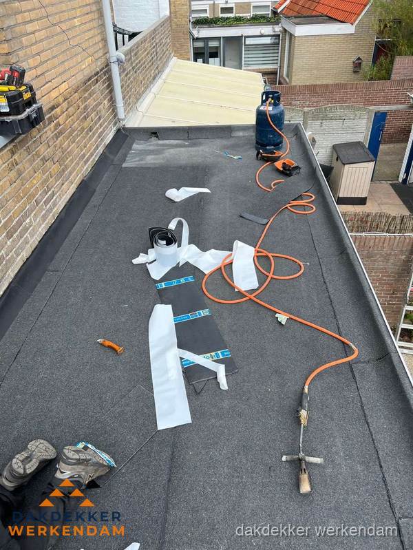 Dakdekkers bezig met bitumen dakbedekking in Werkendam